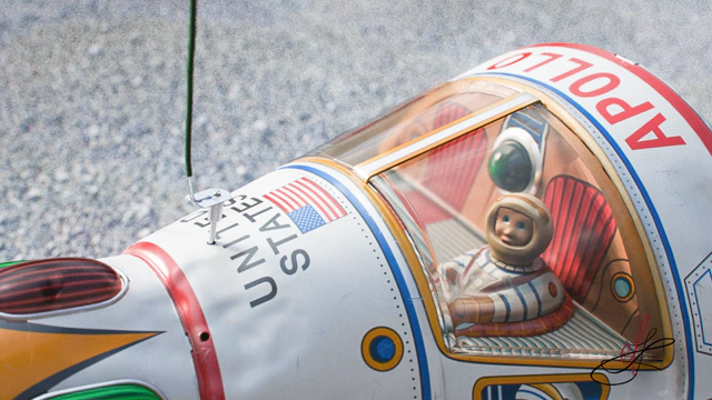 Medium close-up shot of toy's cockpit. cockpit with a tin astronaut sitting in it.